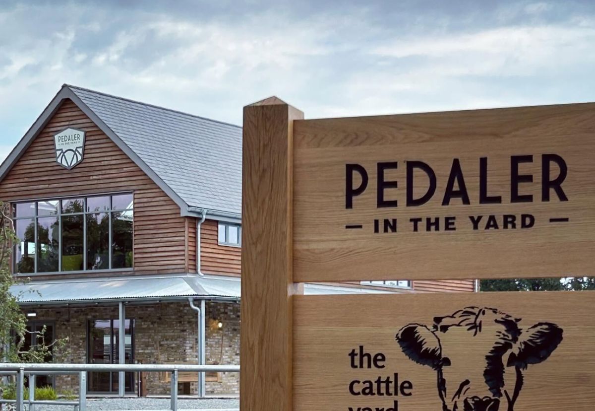 The Independent Pedaler's café building and its wooden sign